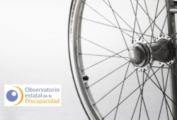 Imagen detalle de la rueda de una silla de ruedas y logo del OED